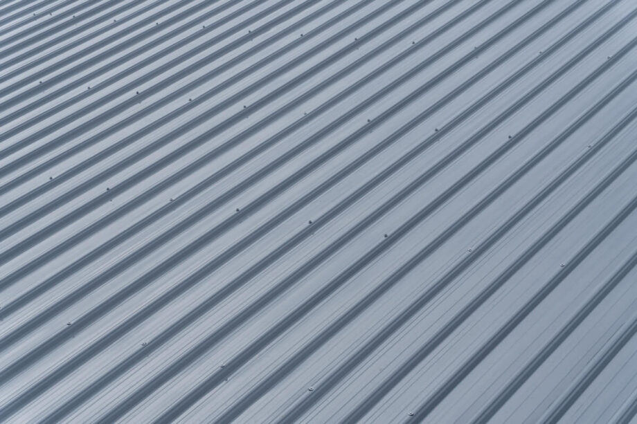 Blacha trapezowa ułożona na dachu w jasnym kolorze.