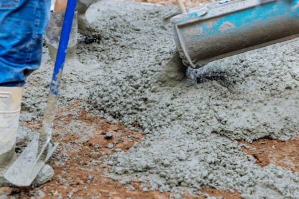 Beton wylewany na ziemię podczas prac budowlanych.